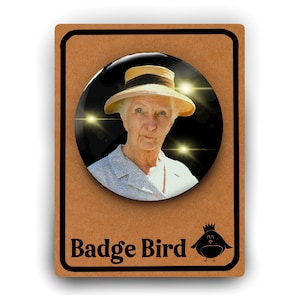 May include: A round button badge featuring a black and white photo of an older woman wearing a straw hat. The background is black with sparkling lights. The text "Badge Bird" is printed below the image.