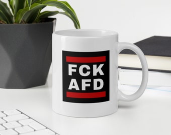 May include: White ceramic mug with a black square design featuring the text "FCK AFD" in white letters with a red horizontal line above and below the text.