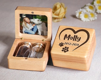 Könnte beinhalten: Holzkiste mit einer herzförmigen Gravur mit der Aufschrift "Molly 2012-2024" und zwei Pfotenabdrücken. Die Kiste hat einen Klappdeckel mit einem kleinen Bilderrahmen, der eine Frau und einen Hund zeigt.
