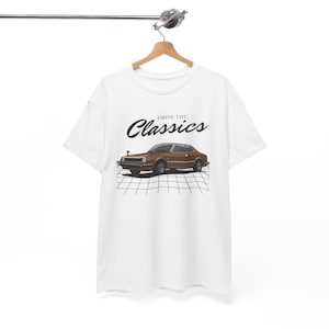 May include: White t-shirt featuring a brown vintage car illustration and the text "Drive the Classics" printed on the front.