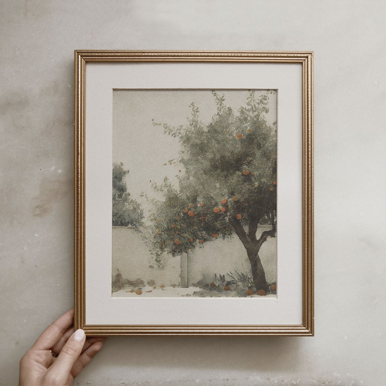 Puede incluir: Una pintura de acuarela enmarcada de un &aacute;rbol con fruta naranja. El &aacute;rbol est&aacute; en un jard&iacute;n con una pared blanca en el fondo. La pintura est&aacute; en un marco dorado.