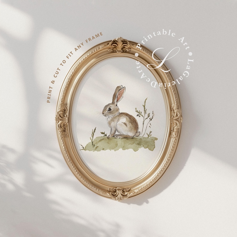 May include: A watercolor painting of a brown rabbit sitting in a field of green grass. The painting is framed in a gold oval frame. The text "Printable Art" is written in a circle around the frame.