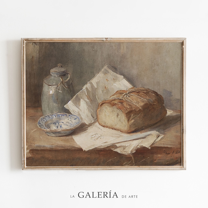 May include: A still life painting of a loaf of bread, a blue and white ceramic jar, and a blue and white ceramic bowl on a wooden table. The bread is wrapped in white paper and tied with string. The painting is framed in a light wood frame.