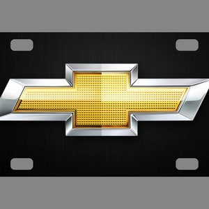 May include: Black license plate with a silver and gold Chevrolet logo.