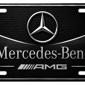 May include: A rectangular black license plate featuring the silver Mercedes-Benz three-pointed star logo at the top. The text Mercedes-Benz is centered below the logo, with the AMG logo and a horizontal line positioned at the bottom of the plate.