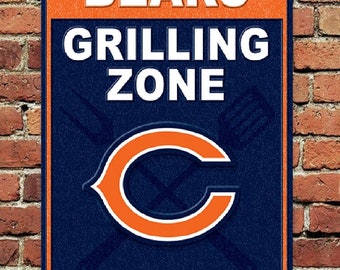 May include: A blue and orange metal sign with the words "Bears Grilling Zone" and the Chicago Bears logo. The sign also says "Be a team player, keep our grill master hydrated."
