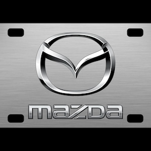 May include: A silver metal license plate frame with the Mazda logo and the word "mazda" in silver lettering.