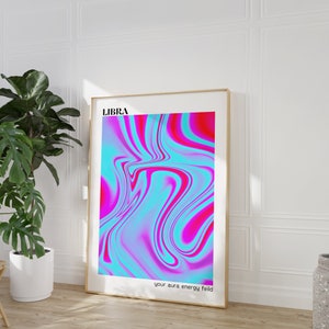 May include: A framed print with a pink and blue abstract design. The print has the word "LIBRA" at the top and the text "your aura energy field" at the bottom.