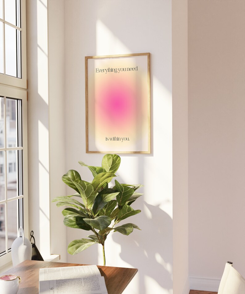 K&ouml;nnte beinhalten: Ein gerahmter Druck mit dem Text "Everything you need is within you." Das Kunstwerk zeigt einen Farbverlauf aus Rosa- und Gelbt&ouml;nen. Der Rahmen hat eine helle Holzfarbe, und der Druck wird an einer wei&szlig;en Wand angezeigt.