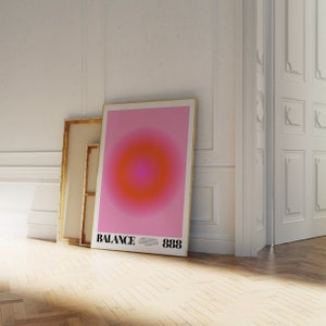 May include: A pink and orange gradient poster with a circle in the center. The poster is framed in gold and has the text "BALANCE 888" at the bottom.