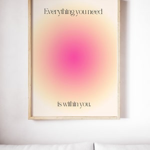 K&ouml;nnte beinhalten: Ein gerahmter Kunstdruck mit einem weichen, farbenfrohen Gradienten-Hintergrund aus Gelb-, Rosa- und Oranget&ouml;nen. Der Text "Everything you need is within you" ist in einer schwarzen, eleganten Schrift dargestellt. Das Kunstwerk befindet sich in einem hellen Holzrahmen.