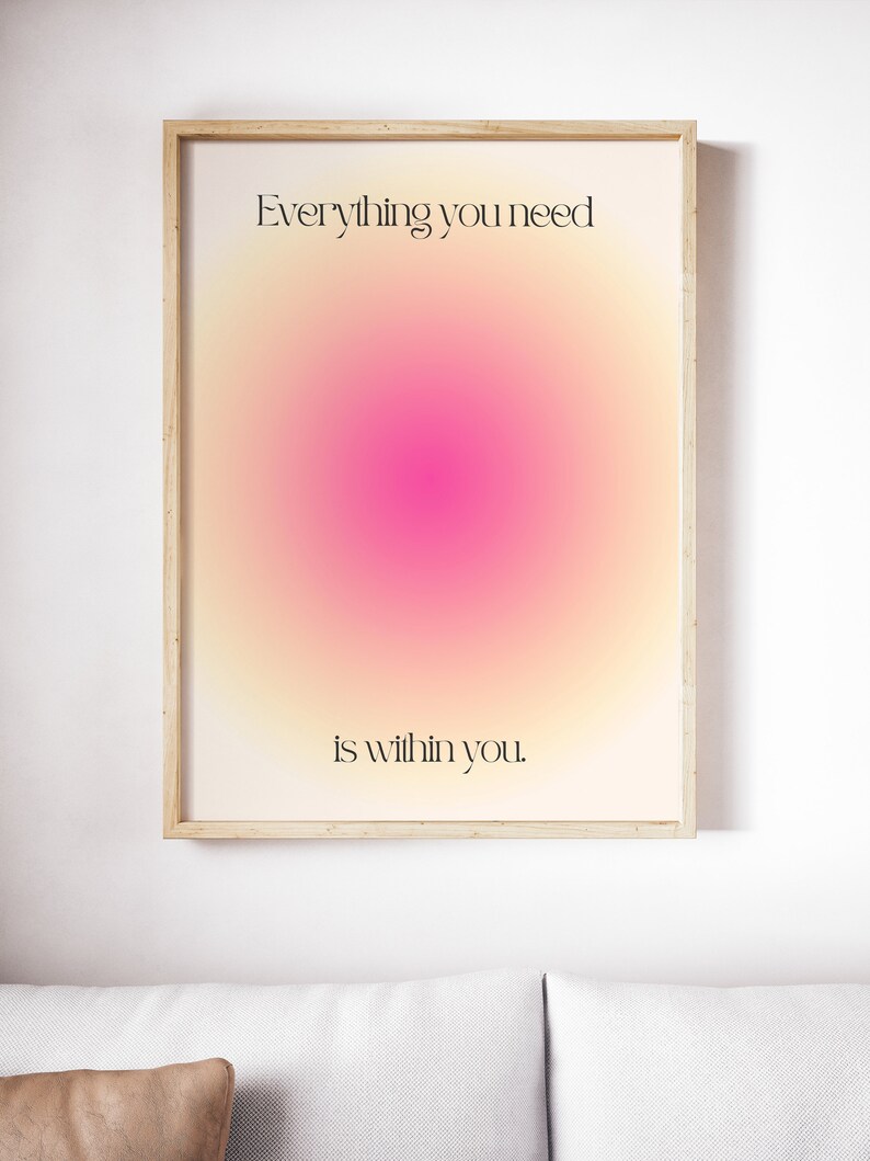 K&ouml;nnte beinhalten: Ein gerahmter Kunstdruck mit einem weichen, farbenfrohen Gradienten-Hintergrund aus Gelb-, Rosa- und Oranget&ouml;nen. Der Text "Everything you need is within you" ist in einer schwarzen, eleganten Schrift dargestellt. Das Kunstwerk befindet sich in einem hellen Holzrahmen.