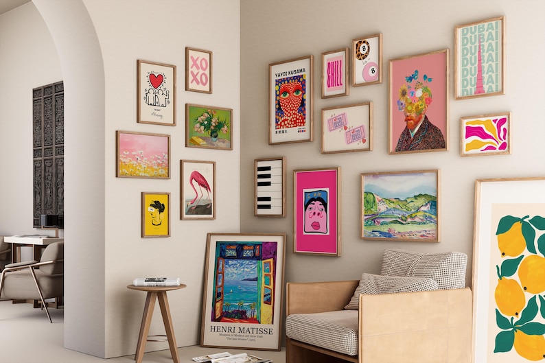 Pode incluir: Uma parede de galeria com impress&otilde;es de arte emolduradas em v&aacute;rios tamanhos e estilos. A cole&ccedil;&atilde;o inclui arte abstrata, retratos e paisagens, com uma mistura de cores e temas. As impress&otilde;es s&atilde;o exibidas em uma parede neutra.
