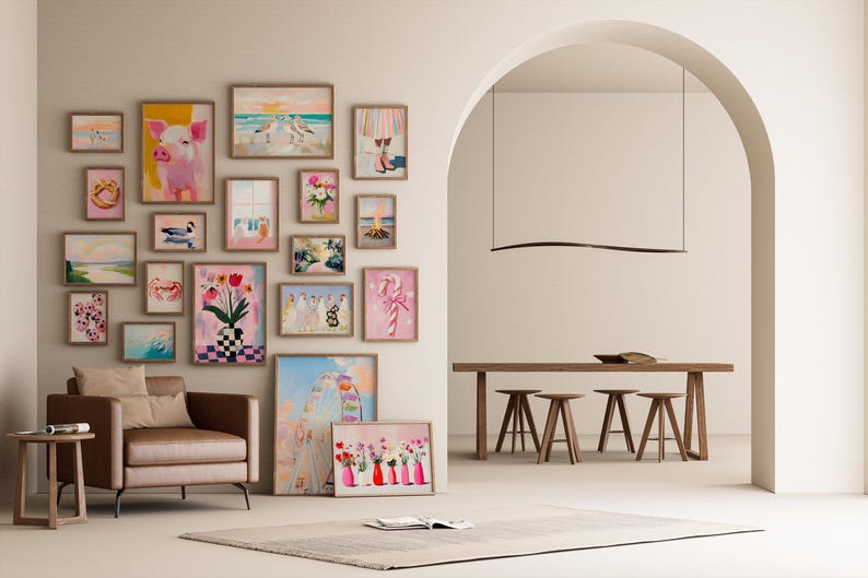 Pode incluir: Uma parede de galeria com impress&otilde;es de arte emolduradas em v&aacute;rios tamanhos e estilos, incluindo uma pintura de porco rosa, arranjos florais e cenas de praia. Uma poltrona de couro marrom e uma mesa lateral est&atilde;o em primeiro plano, com uma &aacute;rea de jantar ao fundo.