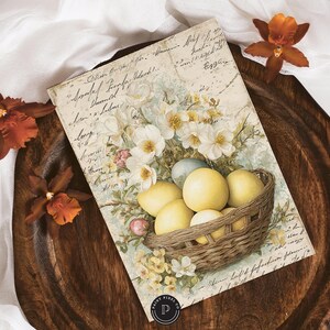 May include: A vintage-style print featuring a basket of yellow eggs, surrounded by white flowers and greenery. The print is on a cream-colored background with script writing. The image is set on a dark wooden tray, with orange orchids.