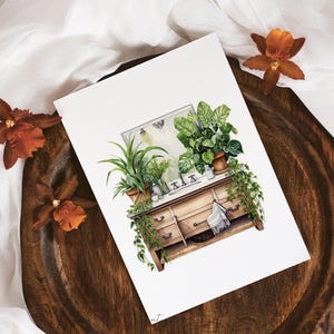 May include: Watercolour illustration of a vintage wooden dresser with a mirror and several potted plants. The dresser has a white countertop and a towel hanging from the drawer. The plants are green and lush, and the overall style is rustic and charming.
