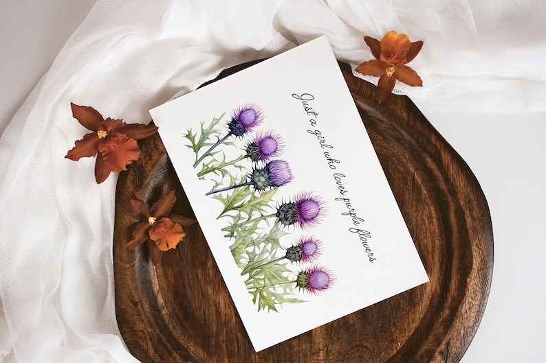 May include: A white card with a watercolor illustration of purple thistle flowers and the text "Just a girl who loves purple flowers".
