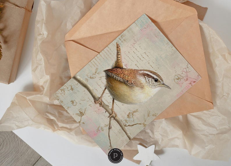 May include: A watercolor print of a Carolina Wren perched on a branch, set against a backdrop of vintage script and floral accents. The bird features brown, tan, and white feathers. The print is on a square card, with a brown envelope.