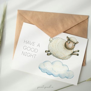 May include: A white card with the text "HAVE A GOOD NIGHT" and a watercolor illustration of a white sheep with brown eyes and hooves flying on a white cloud.