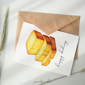 May include: A white card with a watercolor illustration of a stack of golden brown bread slices. The text "Happy Baking" is written in black cursive on the card.