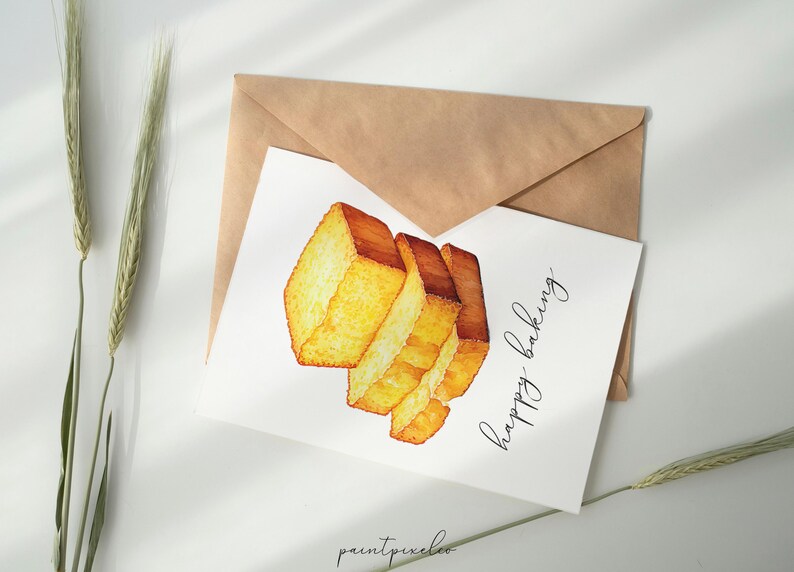 May include: A white card with a watercolor illustration of a stack of golden brown bread slices. The text "Happy Baking" is written in black cursive on the card.