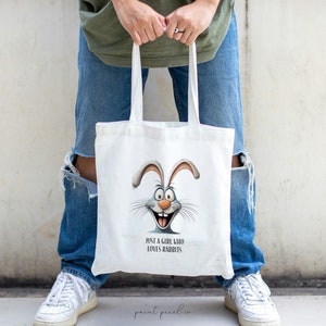May include: A white tote bag with a cartoon bunny rabbit face and the text "Just a girl who loves rabbits".