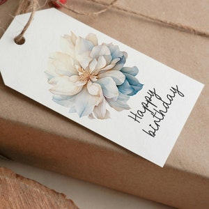 May include: A white gift tag with a blue and white watercolor flower and the text "Happy birthday" in black cursive.