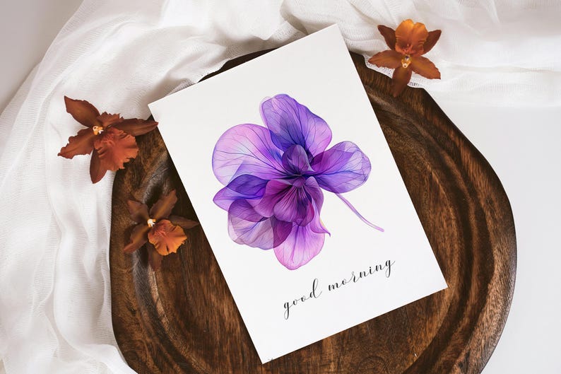 May include: A watercolor painting of a purple orchid with a translucent effect. The painting is on a white card with the text "good morning" written in black ink.
