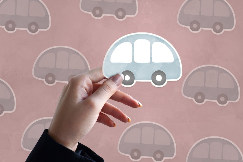 May include: A hand holds up a light blue paper car cutout against a pink background with a pattern of gray paper car cutouts.