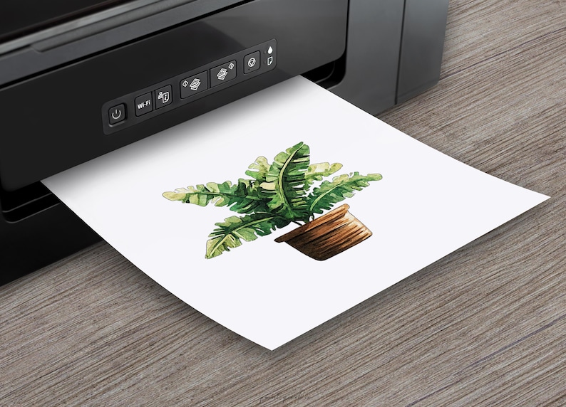 May include: A watercolor illustration of a potted plant with green leaves. The plant is in a brown pot and is printed on a white sheet of paper.