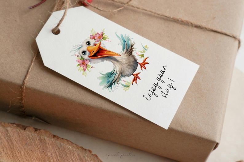 K&ouml;nnte beinhalten: Ein wei&szlig;er Geschenkanh&auml;nger mit einer Cartoon-Illustration eines Vogels, der eine Blumenkrone tr&auml;gt. Der Text auf dem Anh&auml;nger lautet "Genie&szlig;en Sie Ihren Aufenthalt!"
