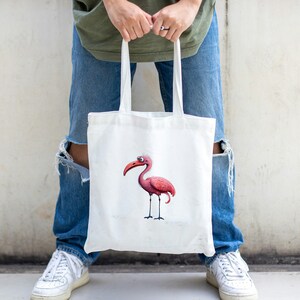 May include: A white tote bag with a pink cartoon bird illustration. The bird has a long beak and large eyes.