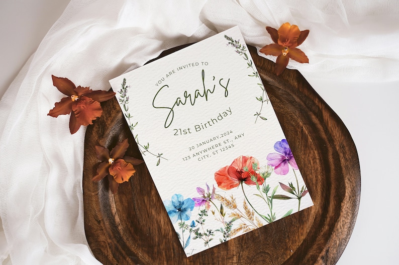 May include: A white invitation card with green lettering that reads "You are invited to Sarah's 21st Birthday" with a floral design featuring red, pink, blue, and white flowers. The date and address are printed below the text.