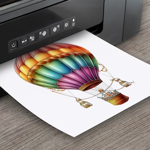 May include: A colorful hot air balloon with a basket and a white background. The balloon is made of a patchwork of different colors, including red, orange, yellow, green, blue, and purple. The basket is made of brown wicker and has a metal frame.