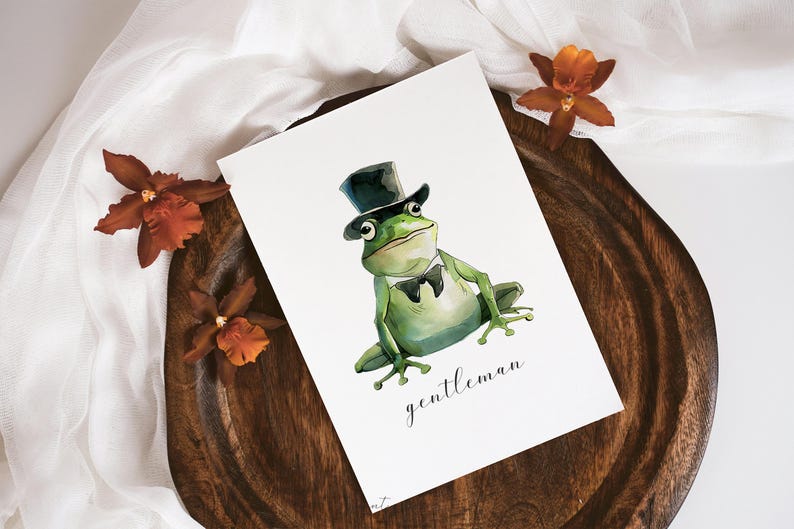 May include: A watercolor illustration of a green frog wearing a black top hat and a bow tie. The frog is sitting on a white background with the word "gentleman" written below it.