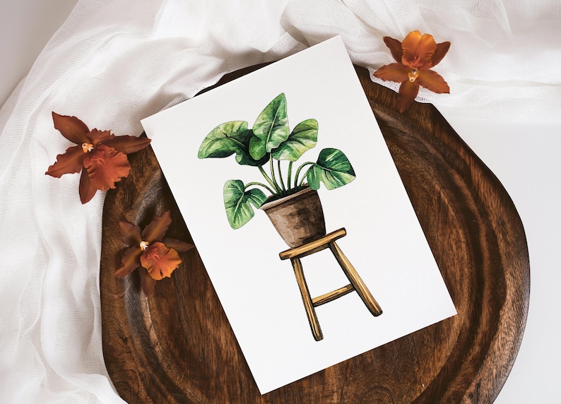 May include: Watercolor painting of a green potted plant on a wooden stool. The plant is in a brown pot and has large, green leaves. The stool is made of light brown wood and has three legs.