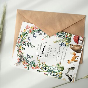 Peut inclure: Une carte d'invitation blanche avec une bordure de couronne florale et des animaux de la for&ecirc;t. Le texte indique "Vous &ecirc;tes invit&eacute; &agrave; l'anniversaire d'Emma F&ecirc;te d'anniversaire Ao&ucirc;t Sam 27 | 15h00 RSVP : N'importe o&ugrave;, N'importe quelle ville".