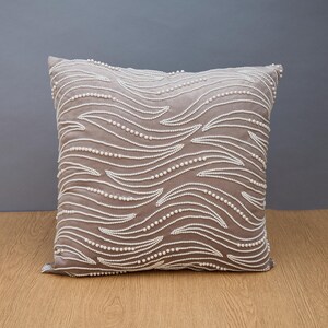 Funda de almohada de lujo con diseño contemporáneo y moderno, con bordado y adorno de terciopelo gris.