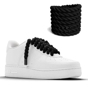 May include: White sneakers with black rope laces. The laces are tied in a unique way, creating a decorative knot on the top of the shoe.