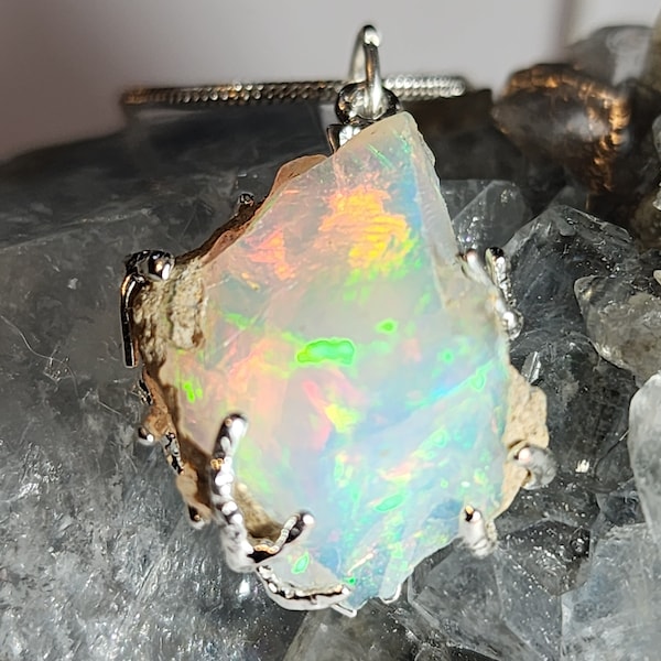 Opal 7.6ct Rough pendant with beautiful play of color wrapped in treebranch wrap setting with optional necklace