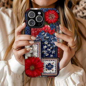 May include: A floral phone case featuring a patchwork design with red, white, and blue flowers. The case has a dark blue background with a variety of floral patterns and a camera cutout.