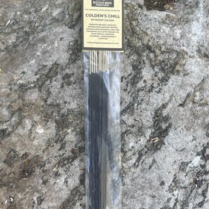 May include: A package of incense sticks with a label that reads "Colden's Chill #11 Mount Colden." The label also mentions aromas of blue spruce, oakmoss, lavender, frankincense, and campfire. The incense is packaged in a clear plastic sleeve.