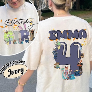 K&ouml;nnte beinhalten: Elfenbeinfarbenes T-Shirt mit dem Text "Birthday Girl" und einer Cartoon-Grafik auf der Vorderseite. Auf der R&uuml;ckseite des Shirts steht der Name "EMMA" &uuml;ber der Zahl "4" mit Cartoon-Figuren. Das Shirt ist von der Marke Comfort Colors.