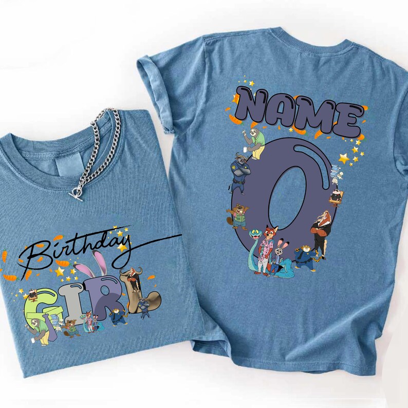 K&ouml;nnte beinhalten: Zwei hellblaue T-Shirts mit Zeichentrickfiguren. Ein Shirt zeigt "Birthday Girl" mit Charakterillustrationen. Das andere Shirt hat das Wort "NAME" &uuml;ber einer gro&szlig;en Zahl "0" mit Charakterillustrationen und Sternen.