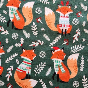 May include: A repeating pattern of orange foxes wearing holiday sweaters and Santa hats on a dark green background. The foxes are surrounded by white snowflakes, leaves, and berries, creating a festive design.