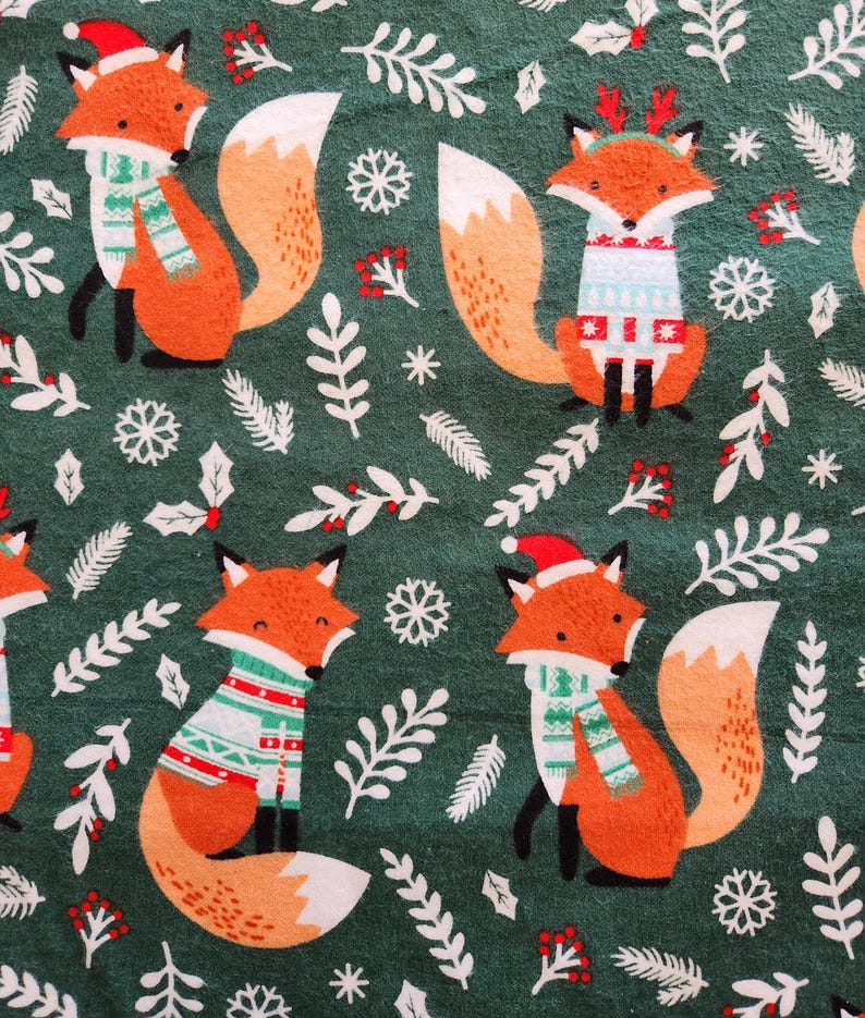 May include: A repeating pattern of orange foxes wearing holiday sweaters and Santa hats on a dark green background. The foxes are surrounded by white snowflakes, leaves, and berries, creating a festive design.