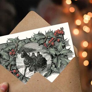 May include: A vintage Christmas card featuring a black and white illustration of a horse-drawn carriage with three people riding through a snowy landscape. The illustration is surrounded by a wreath of holly with red berries.