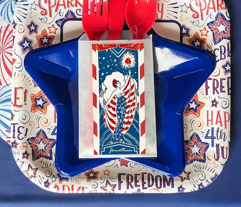 Peut inclure: Une assiette en forme d'&eacute;toile bleue avec une serviette en papier blanche illustrant une femme tenant un drapeau aux couleurs rouge, blanc et bleu. La serviette porte le texte "Jonathan" en bas. L'assiette est sur un fond blanc avec un motif de &eacute;toiles et de feux d'artifice rouge, blanc et bleu.