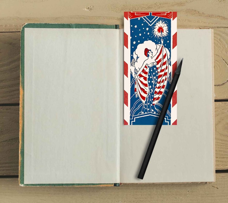 Peut inclure: Un carnet ouvert avec une page blanche &agrave; gauche et un marque-page &agrave; droite. Le marque-page est une illustration vintage d'une femme tenant un drapeau &agrave; rayures rouges, blanches et bleues. Le marque-page porte l'inscription "Liberty Bell".
