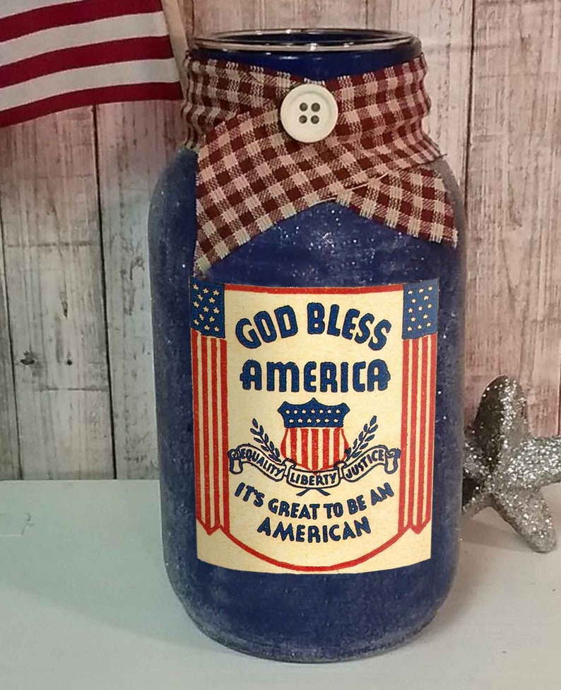 May include: A blue glass jar with a red, white, and blue fabric bow and a label that reads "God Bless America" with a shield and the words "Equality, Liberty, Justice" and "It's Great to Be an American".